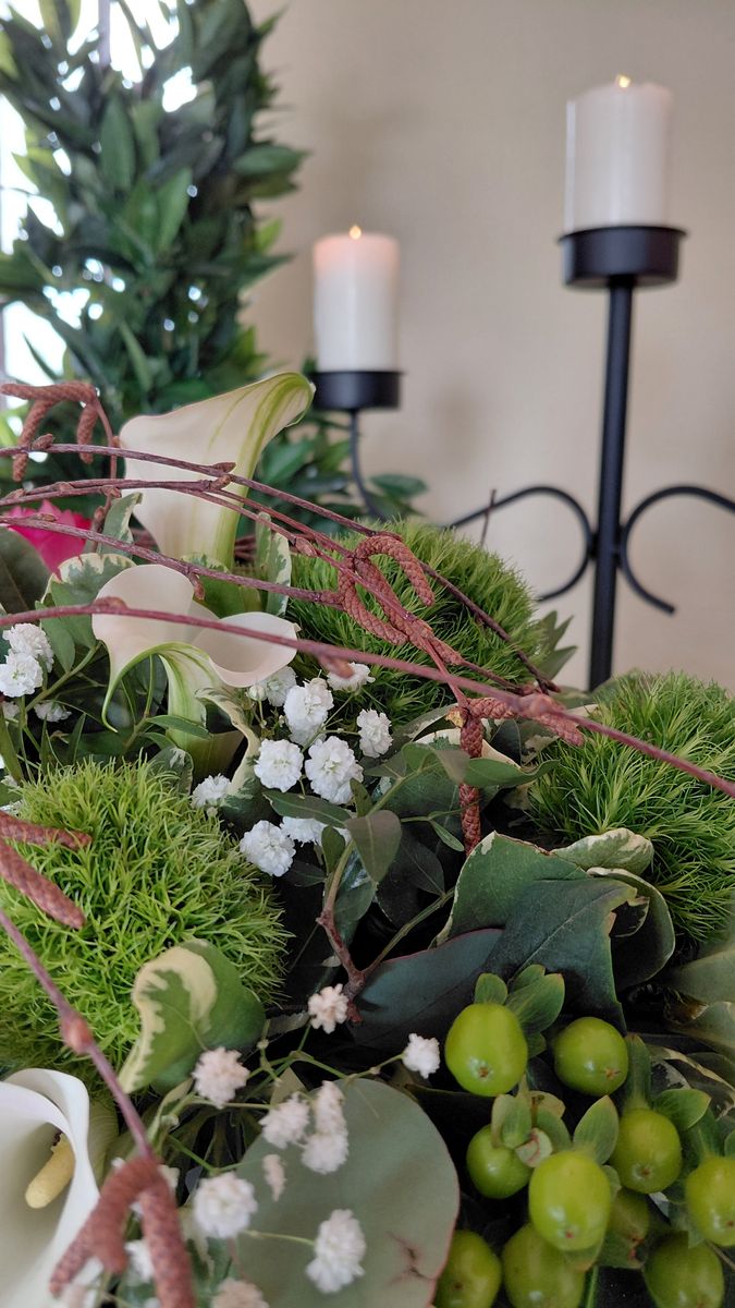Grünes Gesteck mit Callas und Beeren